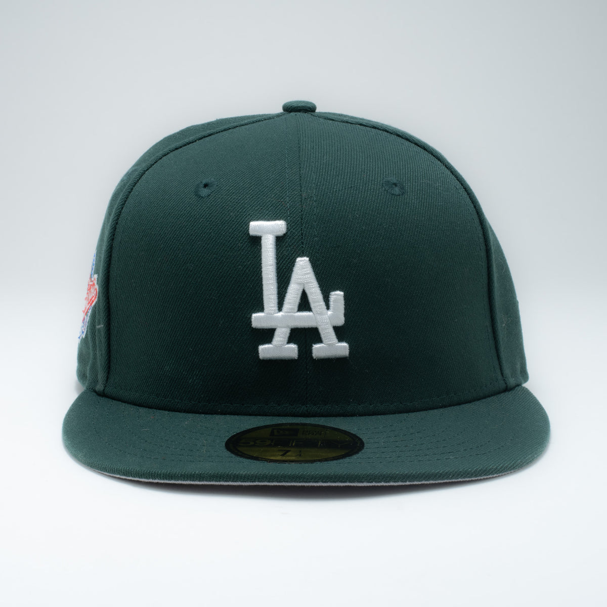 New Era LA Dodgers forest green fitted hat front view showing white LA embroidery and World Series patch
