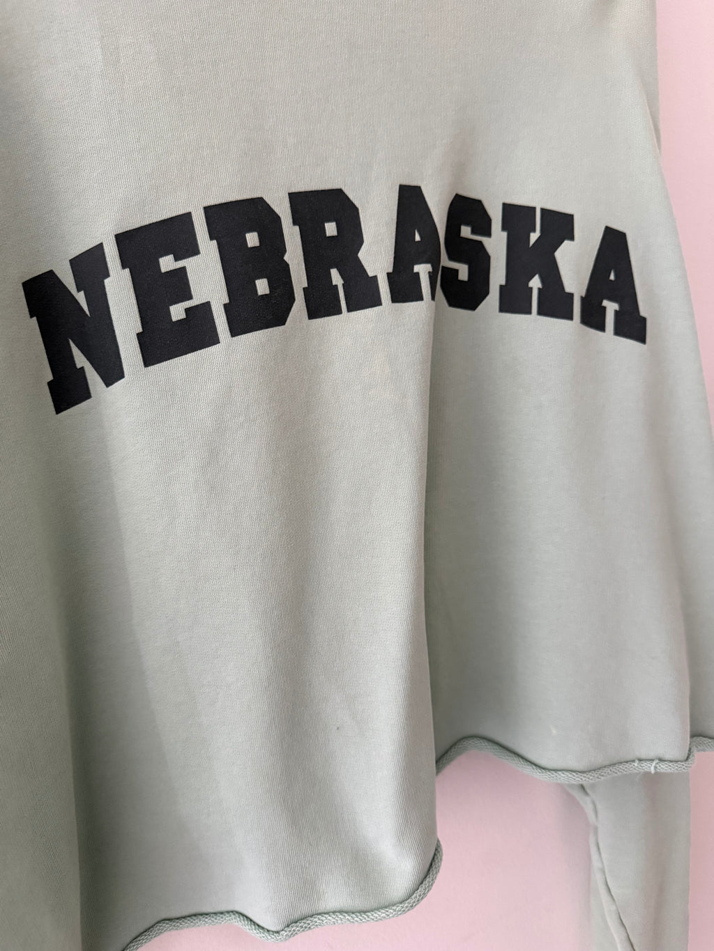 Raf Simons Nebraska crewneck close up of bold black collegiate arch NEBRASKA print on sage mint fleece