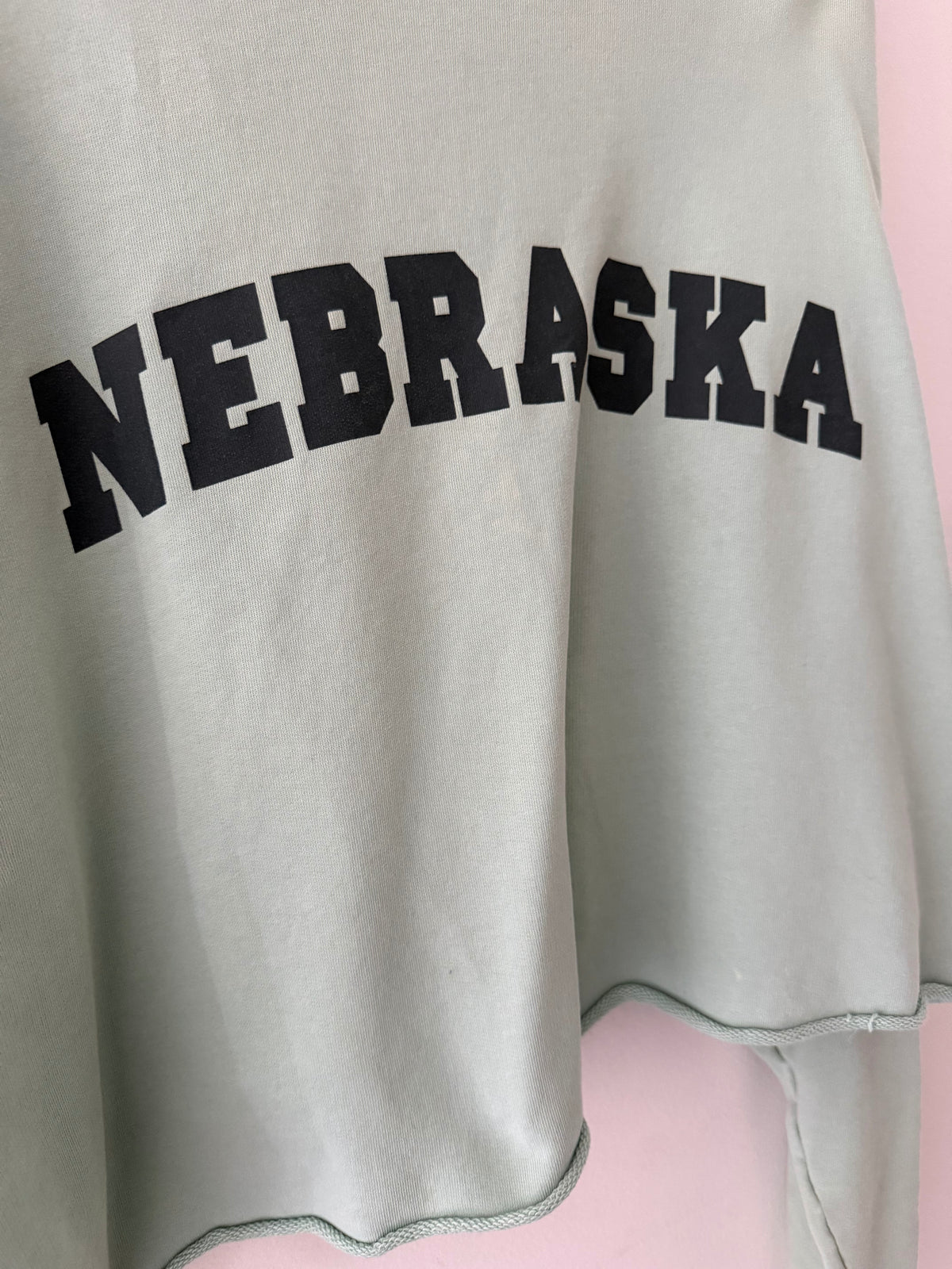 Raf Simons Nebraska crewneck close up of bold black collegiate arch NEBRASKA print on sage mint fleece