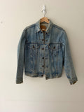 Vintage Levi's denim trucker jacket front view showing faded light wash and button front closure