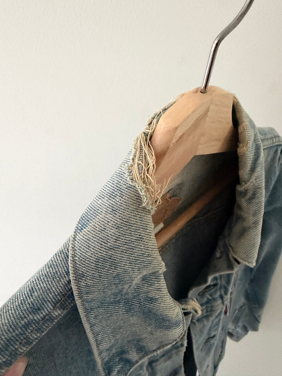 Vintage Levi's denim jacket collar detail showing heavy fraying and distressing
