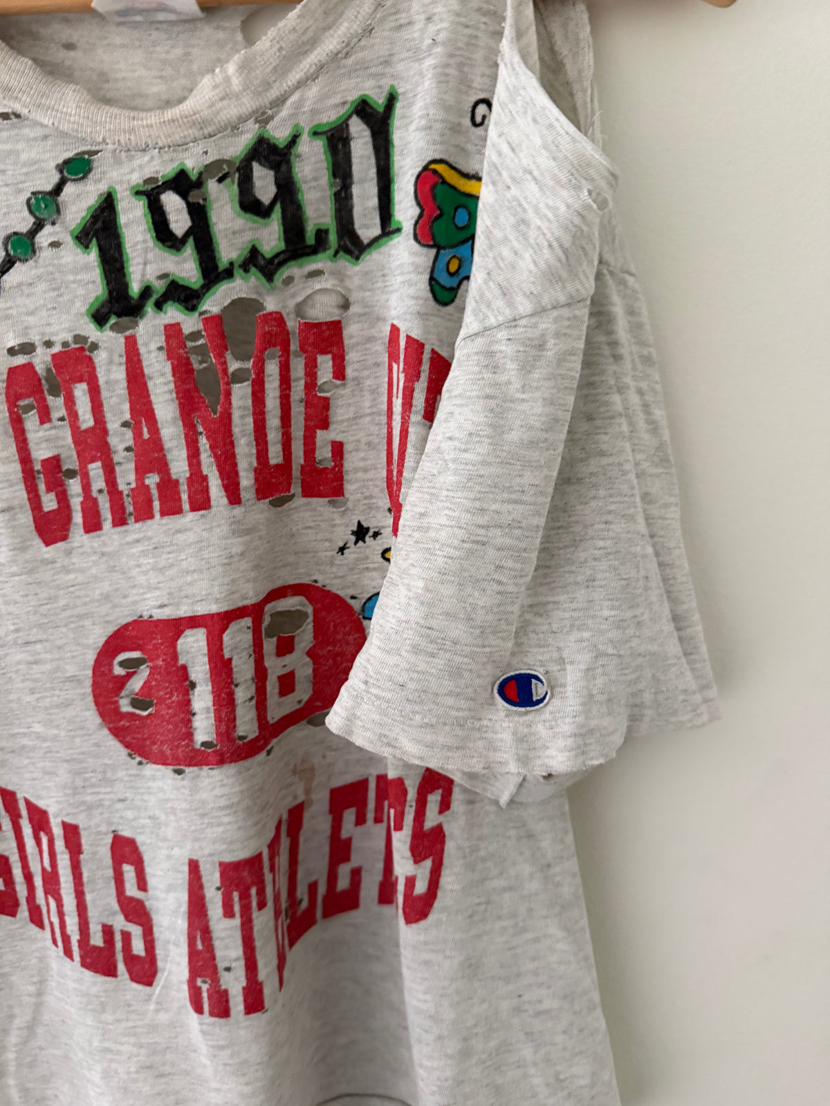 Elephant Man Original Champion tee detail close up showing massive chest holes shredded collar and Champion C logo on sleeve