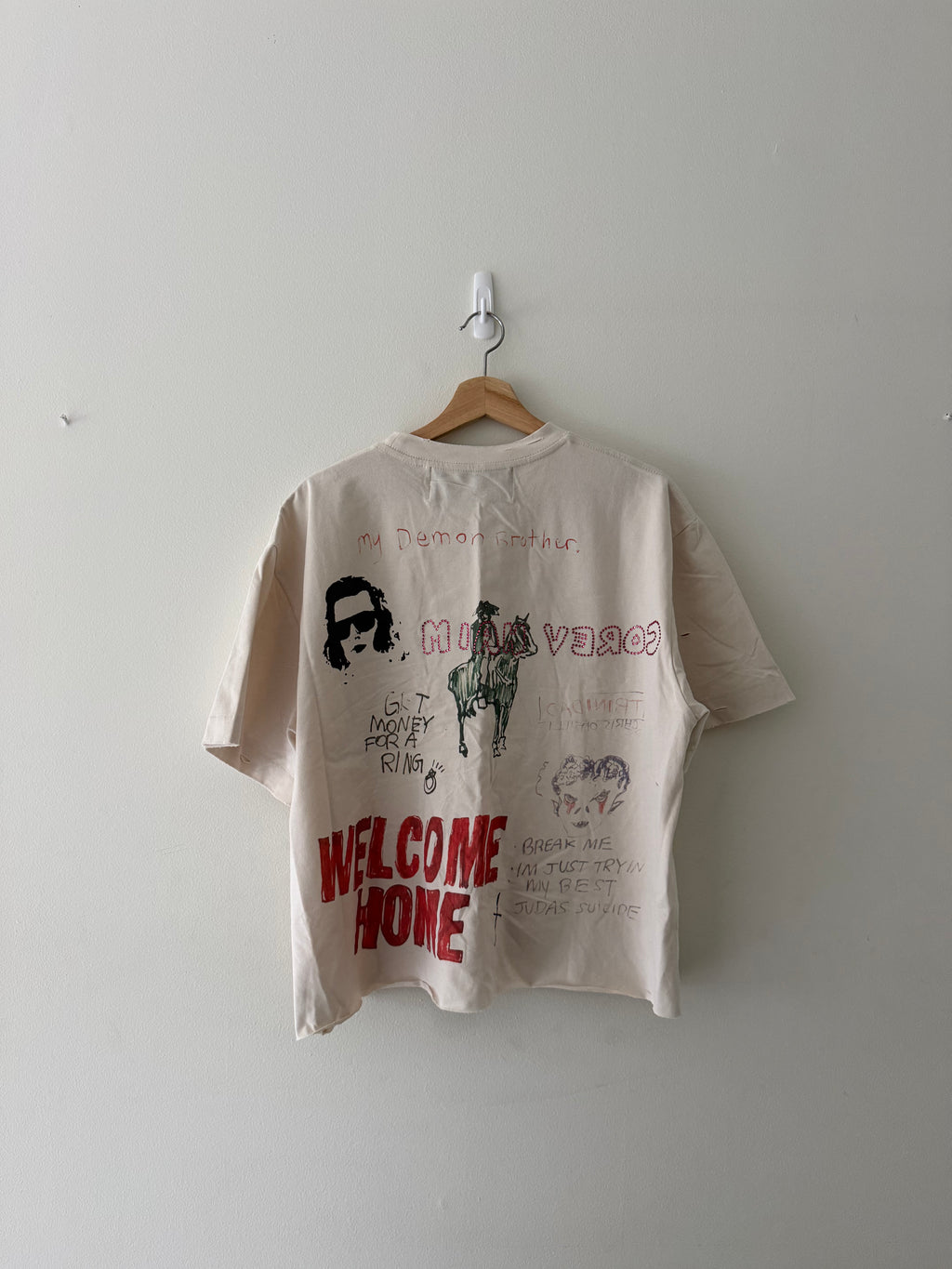Paly Hollywood bedazzled tee back full view showing WELCOME HOME in red block letters and screen printed face