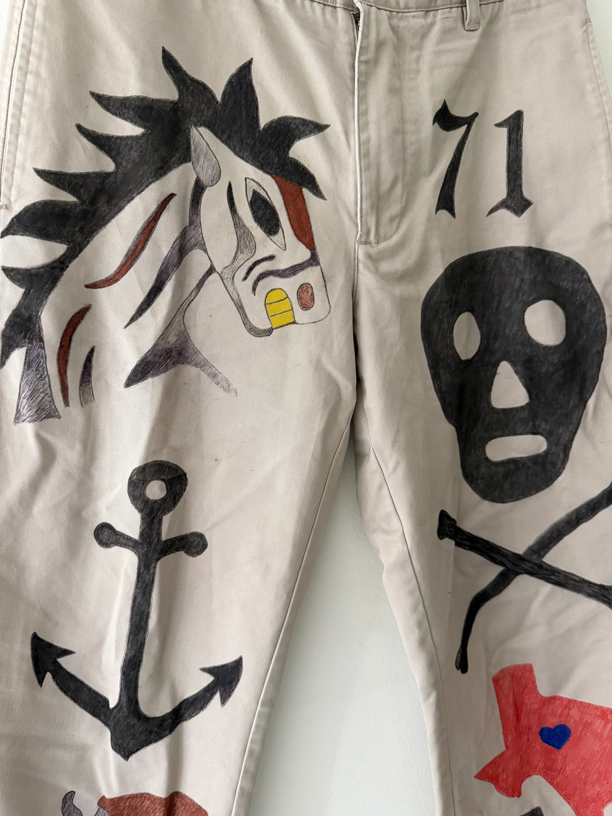 Elephant Man Original khaki trousers front graphic close up showing wild-maned horse with gold teeth skull and crossbones 71 and anchor