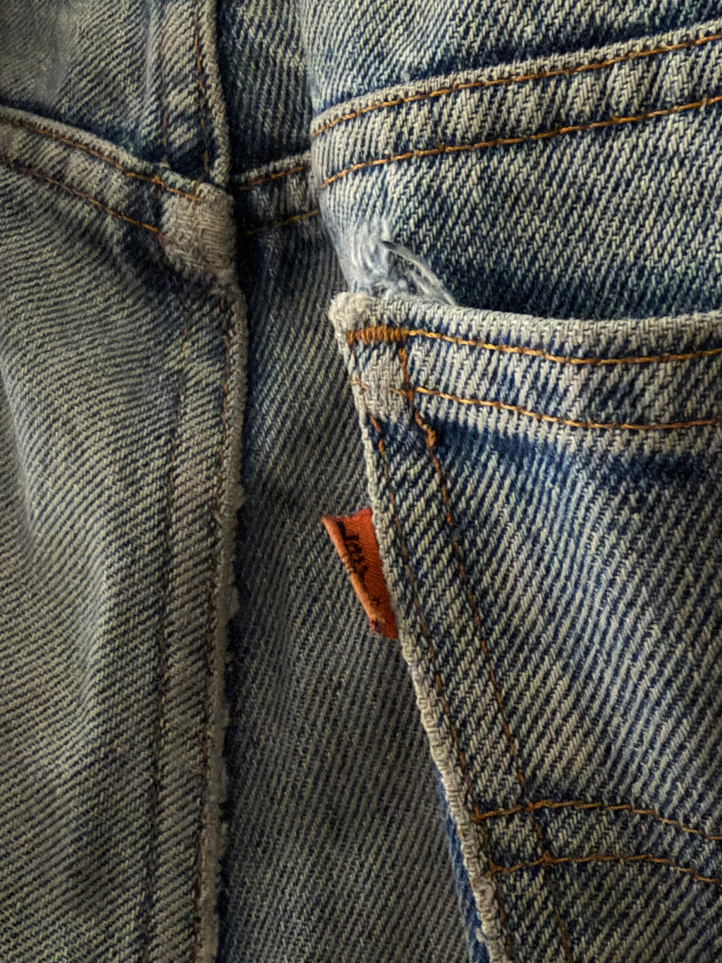 Vintage Levi's Orange Tab denim close up of orange tab on coin pocket with fraying and distressing detail