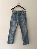 Vintage Levi's 511 with hand-stitched repairs full front view on hanger showing all distressing and repairs