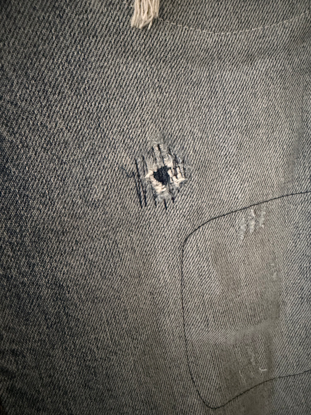 Vintage Levi's 511 left thigh close up showing two smaller tears with exposed white weft threads