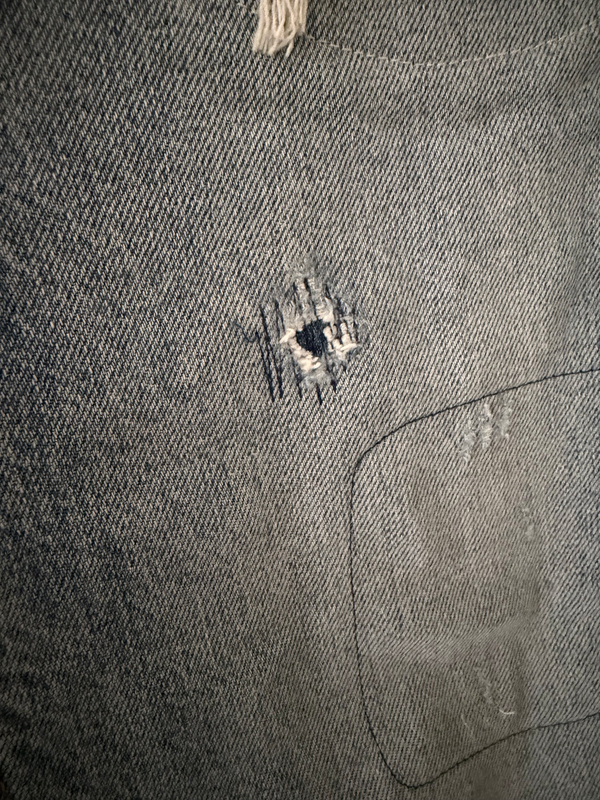 Vintage Levi's 511 left thigh close up showing two smaller tears with exposed white weft threads