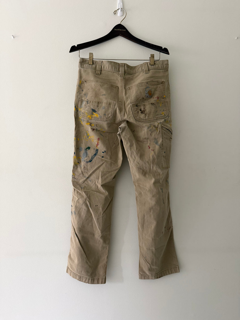 Vintage Carhartt paint-splattered carpenter pants back view showing full paint splatter coverage on khaki canvas